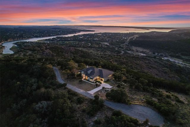 aerial view at dusk featuring a water view