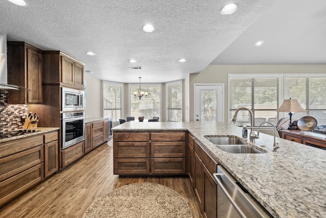 kitchen featuring light hardwood / wood-style flooring, appliances with stainless steel finishes, sink, and a healthy amount of sunlight