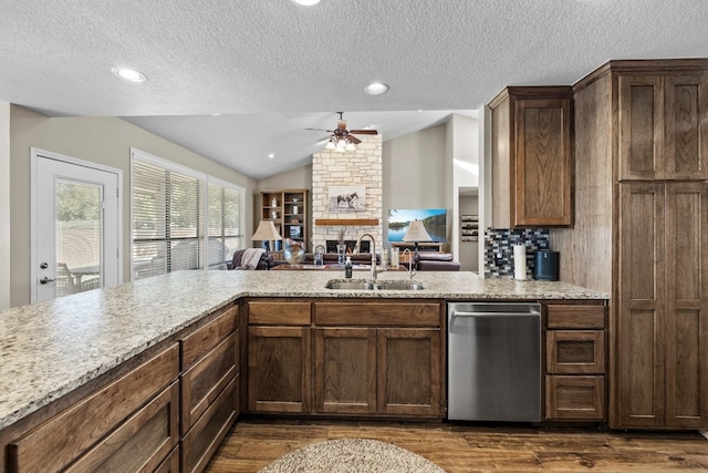 kitchen with lofted ceiling, dark hardwood / wood-style floors, a fireplace, and sink