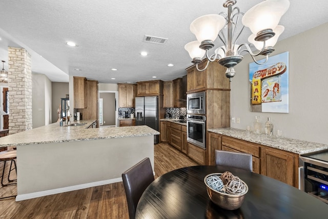 kitchen with hanging light fixtures, sink, tasteful backsplash, stainless steel appliances, and dark hardwood / wood-style floors