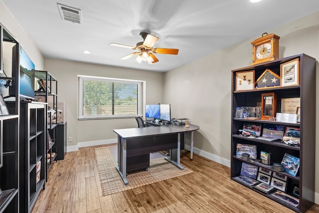 home office with wood-type flooring and ceiling fan