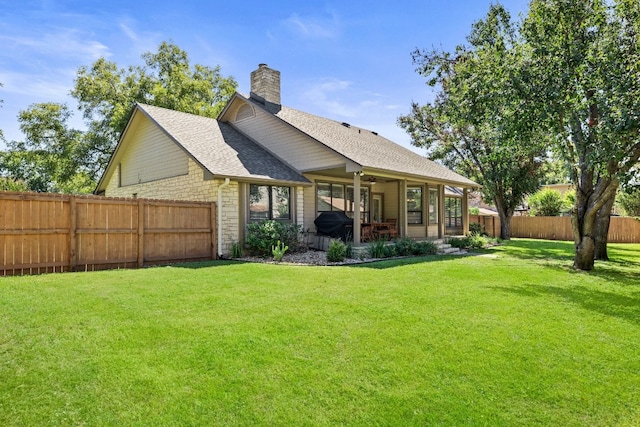 rear view of property featuring a lawn