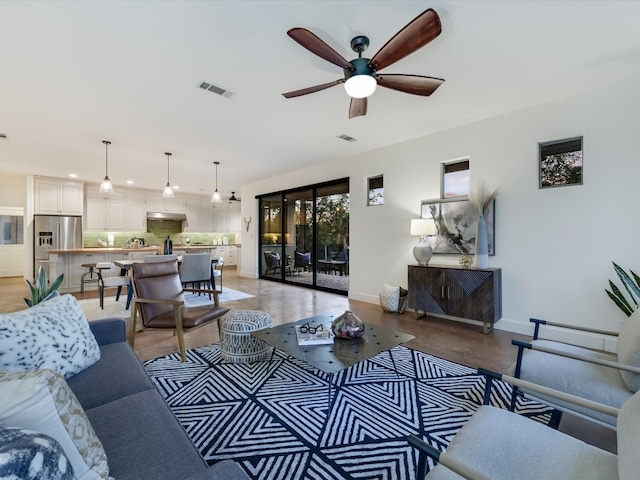 living room featuring ceiling fan and concrete flooring