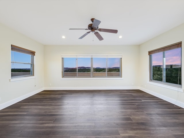 unfurnished room with ceiling fan, dark hardwood / wood-style floors, and a healthy amount of sunlight