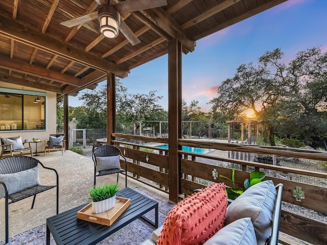 patio terrace at dusk with outdoor lounge area and ceiling fan