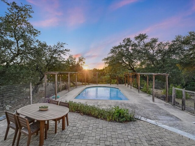 pool at dusk with a patio