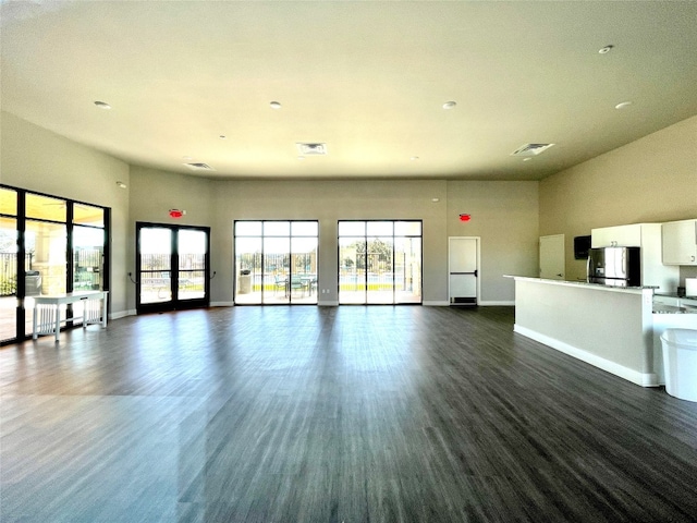 unfurnished living room with dark hardwood / wood-style flooring and a high ceiling