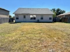 rear view of property featuring a lawn