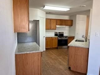 kitchen featuring stainless steel range, sink, and dark hardwood / wood-style flooring