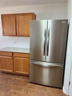 kitchen featuring light hardwood / wood-style flooring and stainless steel refrigerator