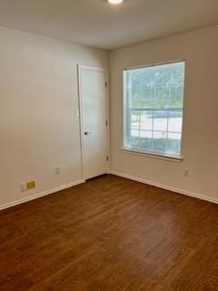 unfurnished room with dark hardwood / wood-style flooring