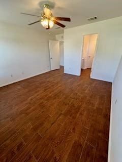 empty room with ceiling fan and dark hardwood / wood-style flooring