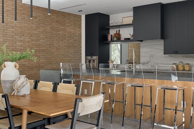 dining room featuring sink and brick wall