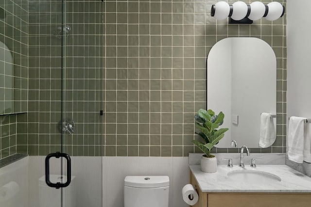 bathroom featuring vanity, an enclosed shower, and toilet