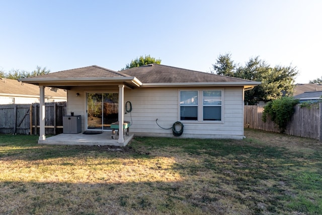 rear view of house with a patio and a lawn