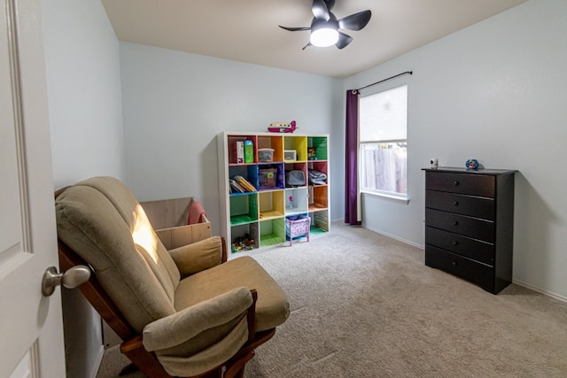 living area featuring light colored carpet and ceiling fan