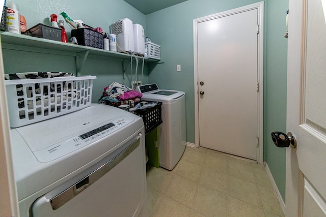 clothes washing area with independent washer and dryer and light tile patterned floors