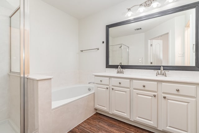 bathroom with vanity, independent shower and bath, and wood-type flooring