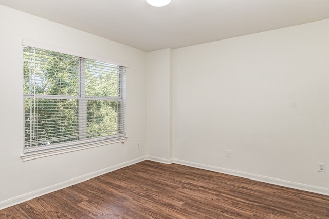 empty room with plenty of natural light and dark hardwood / wood-style flooring