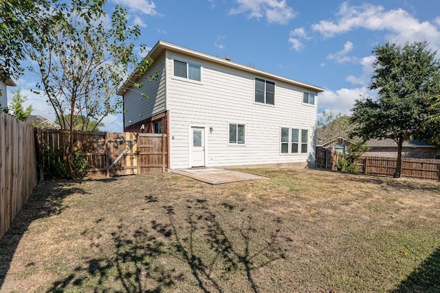 back of house featuring a lawn and a patio area