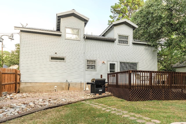 back of property with a lawn and a deck