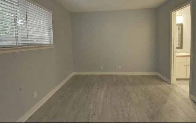 unfurnished room with hardwood / wood-style flooring and sink