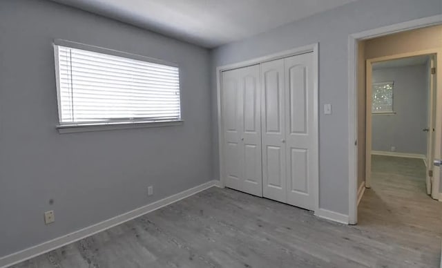 unfurnished bedroom with light hardwood / wood-style flooring and a closet