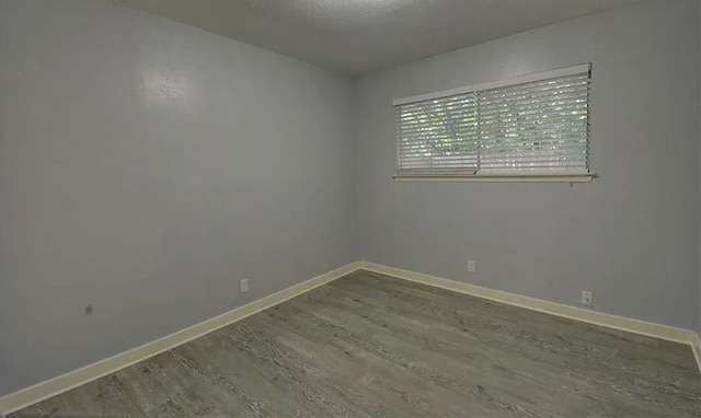 unfurnished room with hardwood / wood-style flooring