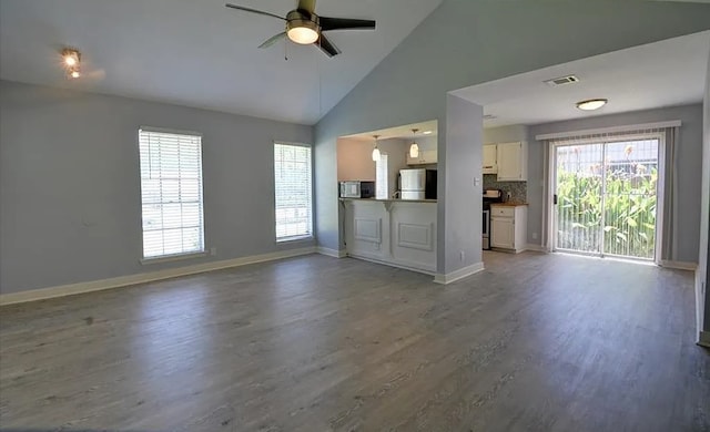 unfurnished living room with a healthy amount of sunlight, hardwood / wood-style floors, and ceiling fan