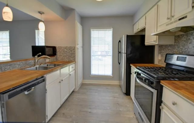 kitchen with pendant lighting, appliances with stainless steel finishes, sink, and a healthy amount of sunlight