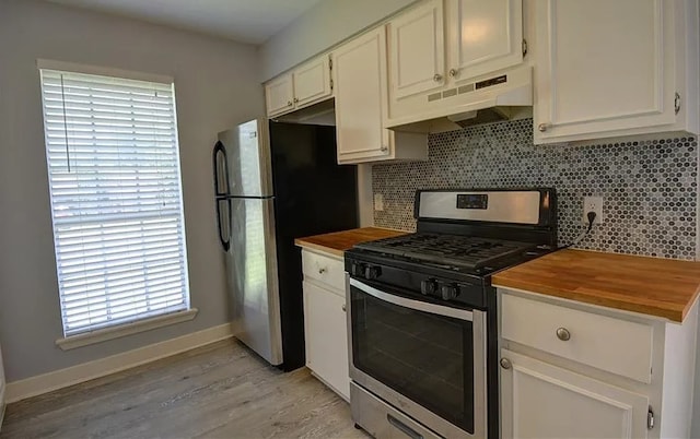 kitchen featuring wooden counters, light hardwood / wood-style flooring, white cabinetry, stainless steel appliances, and decorative backsplash