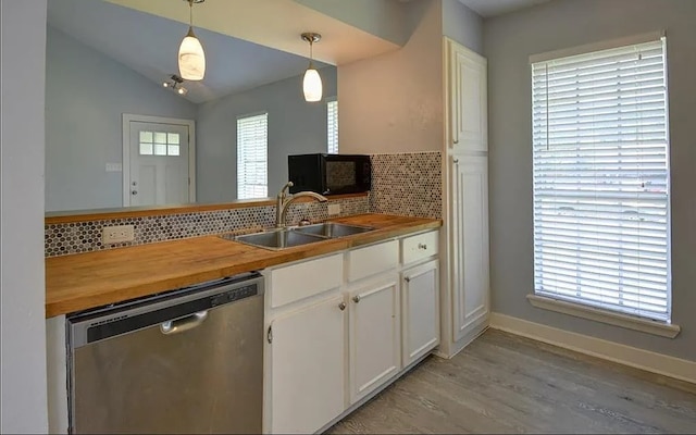 kitchen featuring decorative backsplash, white cabinetry, dishwasher, decorative light fixtures, and sink