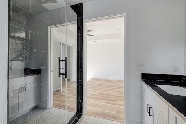 bathroom with vanity, hardwood / wood-style flooring, and a tile shower