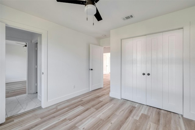 unfurnished bedroom featuring light hardwood / wood-style floors, ceiling fan, and a closet