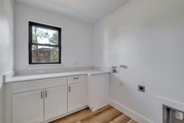 laundry room featuring light wood-type flooring, electric dryer hookup, washer hookup, and cabinets