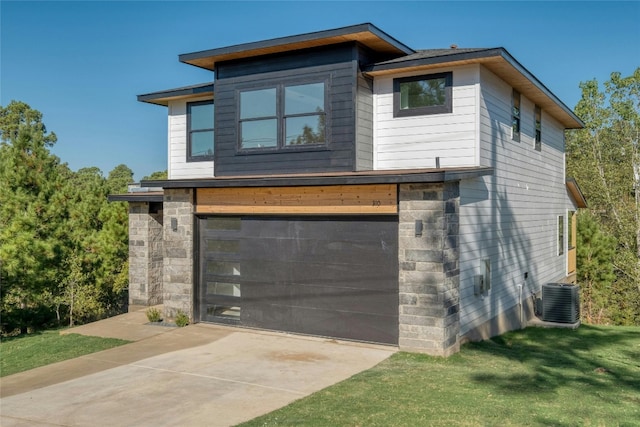 exterior space featuring central AC unit, a garage, and a front yard