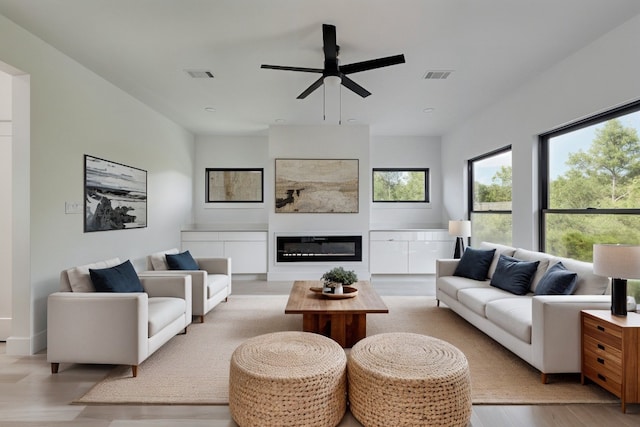 living room with light wood-type flooring and ceiling fan