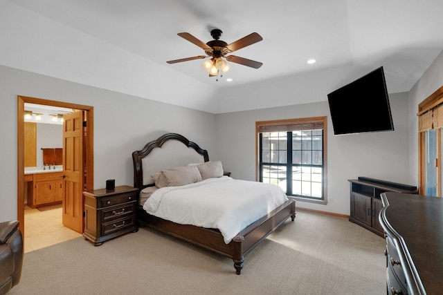 bedroom featuring ceiling fan, light colored carpet, and ensuite bathroom