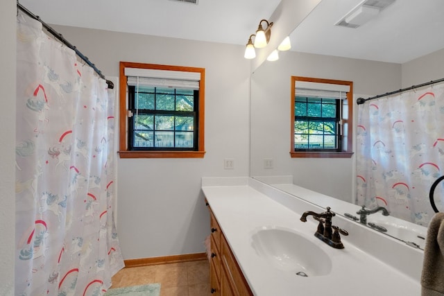 bathroom featuring vanity, tile patterned flooring, a shower with curtain, and a healthy amount of sunlight