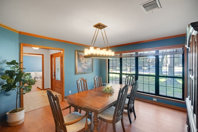 dining space featuring light hardwood / wood-style flooring and crown molding