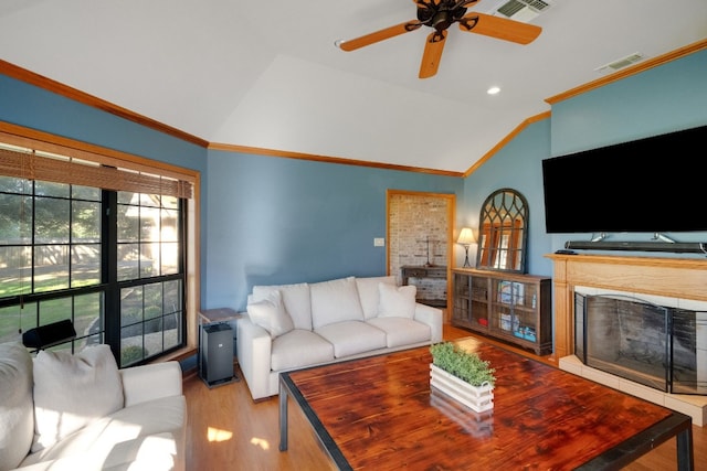 living room featuring ceiling fan, lofted ceiling, ornamental molding, and light hardwood / wood-style flooring