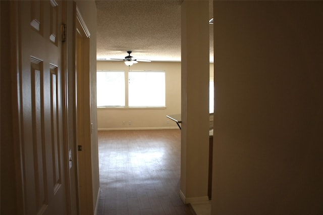 hall with hardwood / wood-style flooring and a textured ceiling