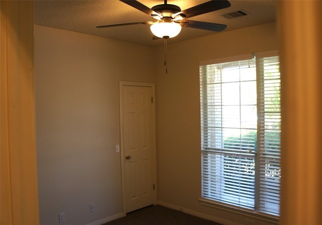 unfurnished room featuring ceiling fan and a textured ceiling