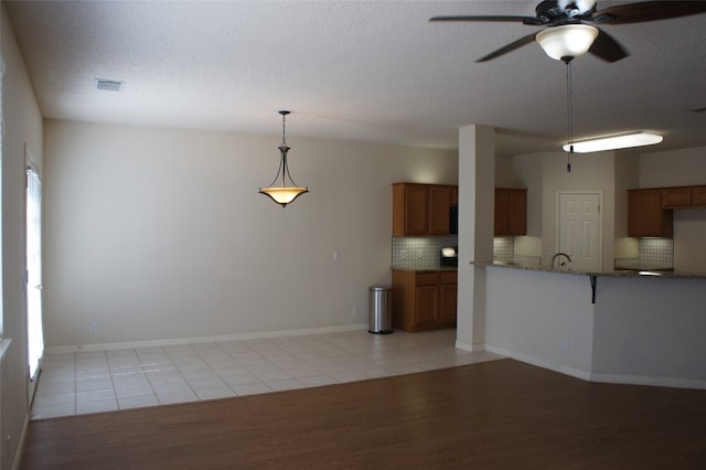 interior space with light hardwood / wood-style floors, ceiling fan, and a textured ceiling