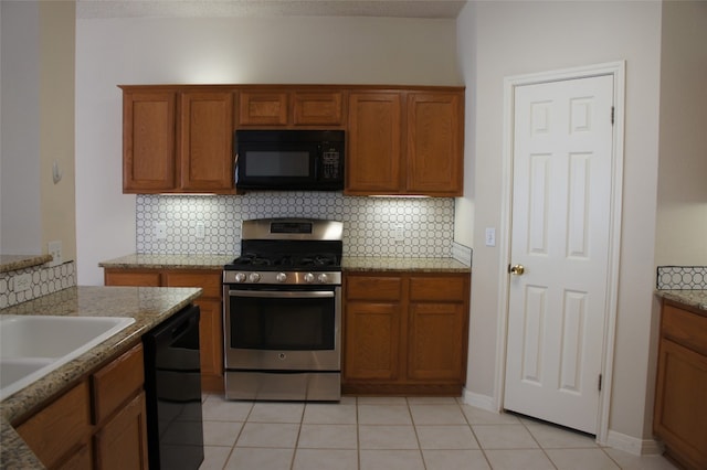 kitchen with black appliances, light tile patterned floors, light stone counters, and tasteful backsplash