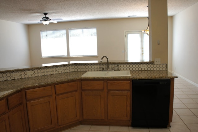 kitchen with black dishwasher, plenty of natural light, sink, and a textured ceiling