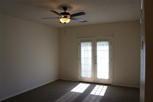 carpeted empty room featuring ceiling fan, french doors, and a textured ceiling