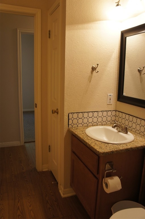 bathroom featuring vanity, toilet, and hardwood / wood-style flooring