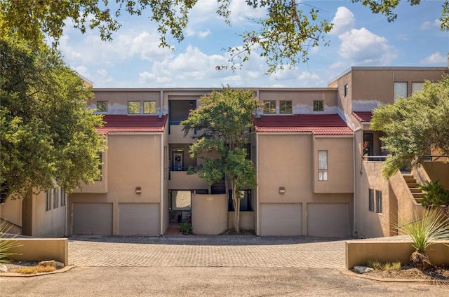 view of property featuring decorative driveway and an attached garage