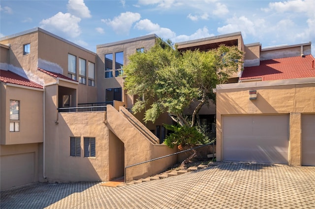 view of front of property featuring a balcony and a garage